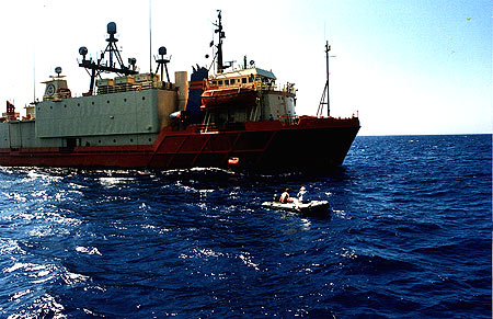 Our tiny boat up against the Navy's deployment boat